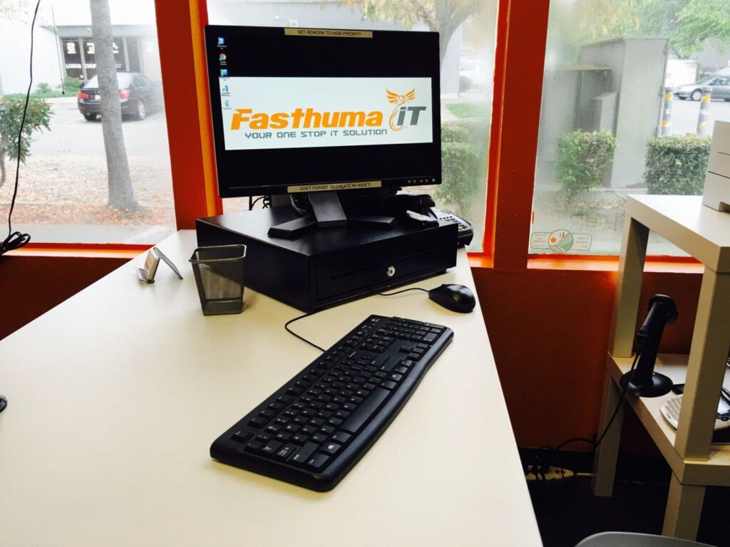 Front desk at the Fasthuma iT office with a computer showing the Fasthuma iT logo
